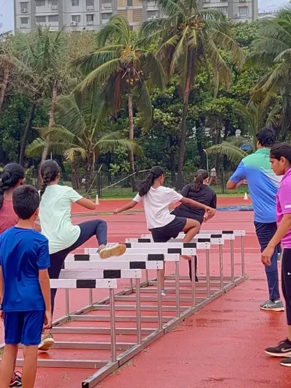 I provide hands-on coaching for all my athletes. Here, a coach carefully guides young hurdlers, correcting their form to ensure they learn the proper technique safely and effectively.
