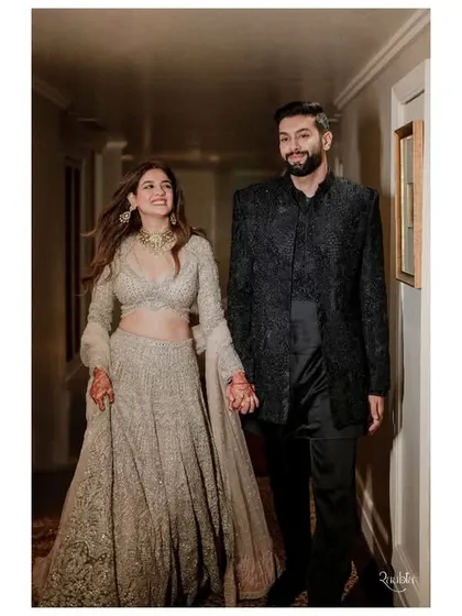 A candid shot of the couple walking down a hallway, hand in hand, capturing a simple moment of togetherness.