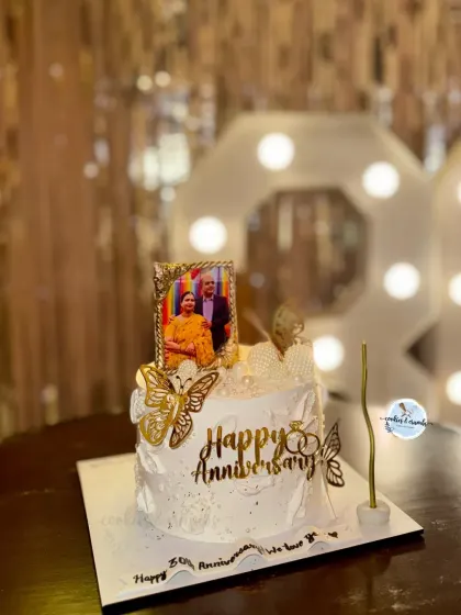 Celebrating 30 years of love with this special anniversary cake. It features an edible photo frame, golden butterflies, and delicate details, all set against a backdrop of romantic rose petals.