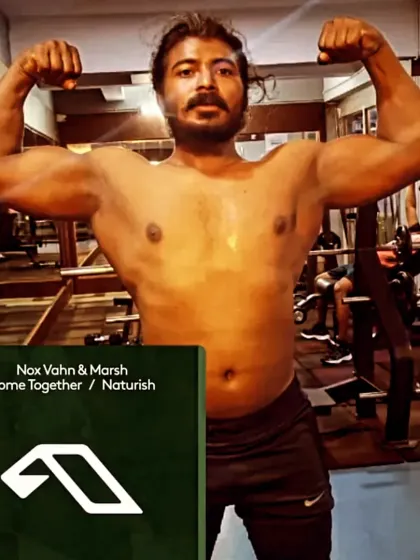 A classic front double biceps pose in the gym. This is a fundamental pose for any bodybuilder, showcasing arm size, chest fullness, and shoulder width.