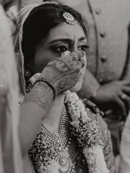 An emotional, black and white close-up of the bride, Shikha, during a poignant moment in her wedding ceremony.