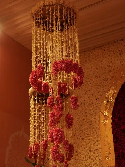 A unique floral chandelier made from strings of tuberose and rings of red carnations. This traditional craft is elevated into a stunning piece of decor.