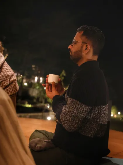 A student enjoying a warm drink during a cool evening session. Creating a comfortable and nurturing environment is essential for our community to relax and open up.