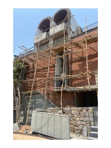 The Brick Vault House nearing completion, with the exposed brick cladding and grit wash finish applied. The white broken china mosaic on the curved roof surfaces helps reflect heat, a low-tech and effective sustainability feature.