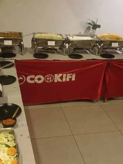 A full buffet spread featuring a variety of main courses and a fresh salad bar for a house party.