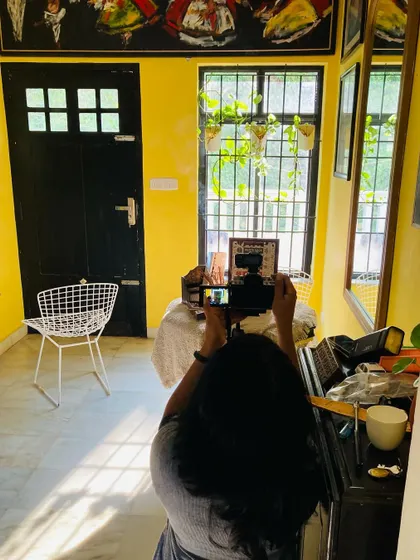 A behind-the-scenes photo of me setting up a shot in a vibrant yellow room. This shows how I use natural light and the environment to create the perfect composition.