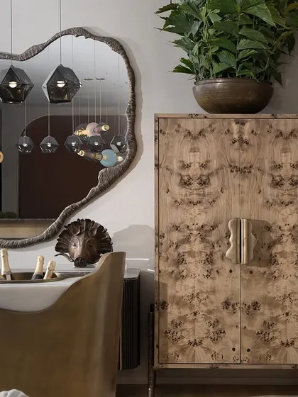A reflection of a different lighting installation in a mirror, framed by the elegant furniture and a striking burl wood cabinet. This image shows how I curate entire spaces, not just lighting.