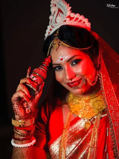 A happy and confident portrait of the Bengali bride with her sindoor box. Her bright smile and direct gaze make this a joyful and engaging photo.