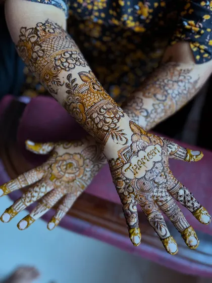 Here you can see the name "Thaheem" beautifully integrated into the palm of this signature floral design, a perfect example of personalized bridal art.