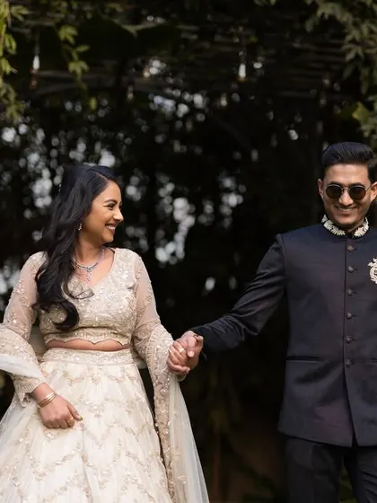A happy, candid shot of the couple walking hand-in-hand after their engagement. His cool sunglasses and her joyful smile perfectly capture the celebratory mood.