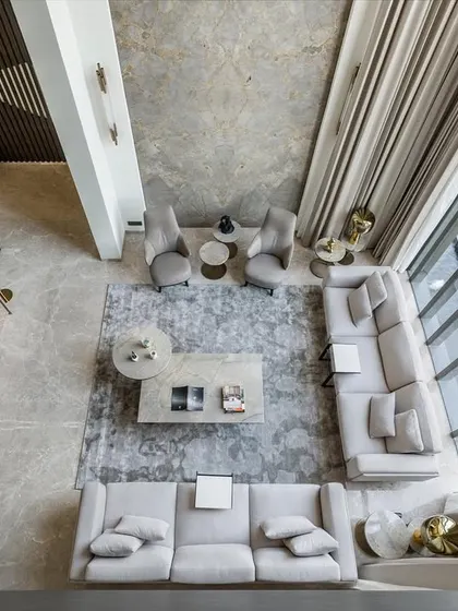 A top-down view of the living area in Silhouette, highlighting the double-height space and connection to the outdoors. The layout is designed to feel expansive and airy, with furniture arranged to foster conversation and relaxation.