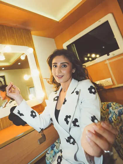 A happy behind-the-scenes moment. This shot captures the fun and playful energy of this chic floral suit.