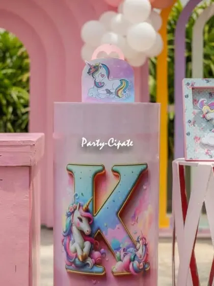 A close-up of the personalized pedestal for Kashni's party, featuring her initial 'K' and unicorn graphics. These custom details make the setup extra special.