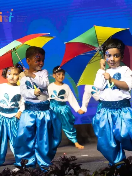 Children hold colorful umbrellas as part of their dance for Neera, representing a joyful rain shower.
