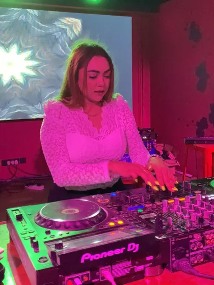 Mixing in front of a screen with psychedelic visuals, adding to the atmosphere.