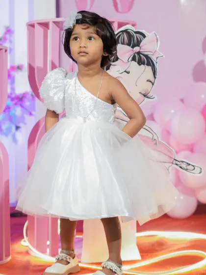 A final look at the modern white party dress, showcasing its elegant yet playful design. I work with parents to create personalized birthday dresses that capture their child's personality perfectly.