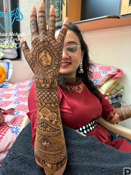 A client proudly showing off her full-arm mehndi. This design is a great example of a traditional style without human figures, focusing on intricate patterns and auspicious symbols.