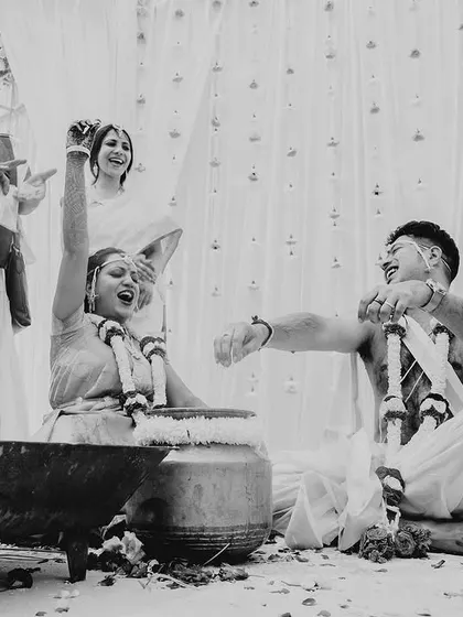 A black and white photo capturing a moment of fun and games during a South Indian wedding.