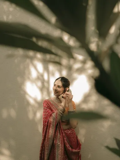 A candid moment of the bride adjusting her earring, a small, beautiful detail.