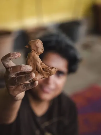 Sometimes, the most profound stories are held in the smallest of things. A participant holds up a figure she created during a clay workshop. This is a moment of pure creation, a tangible piece of a personal journey made visible through art.