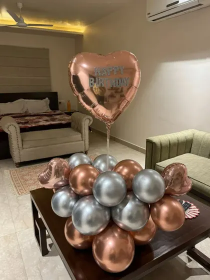 A simple and elegant balloon bouquet for a birthday surprise. The rose gold and silver balloons are perfect for a sophisticated celebration at home.