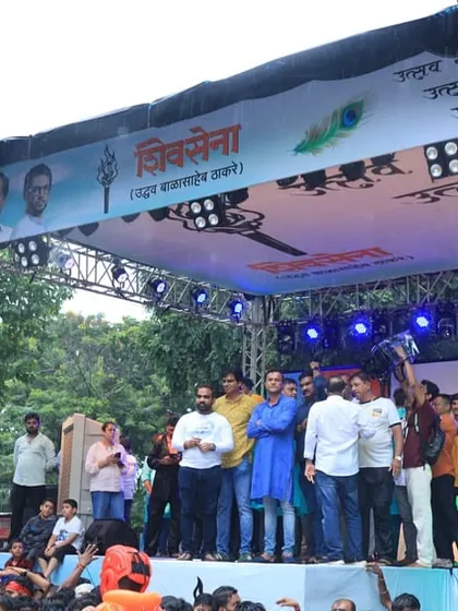 A wide view of the stage setup for the Dahihandi festival, showing the truss structure, speakers, and banners. We provide the complete technical infrastructure for large outdoor events.