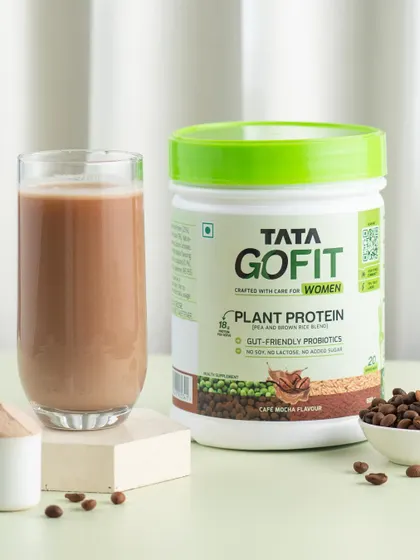 A prepared protein shake next to the product container and raw ingredients. This type of shot tells the full story from powder to finished drink.
