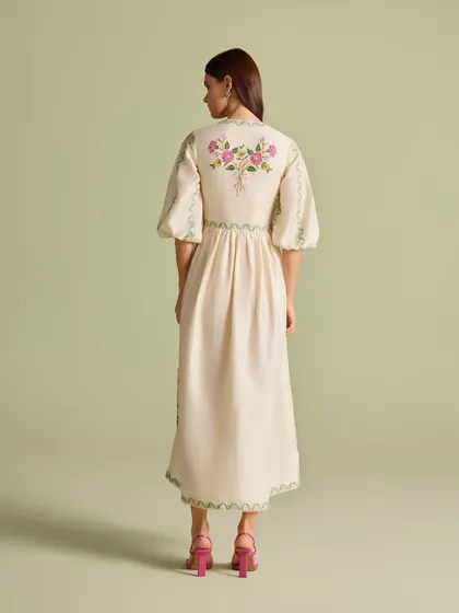 The back view of the dress, highlighting the delicate bouquet of flowers embroidered between the shoulders.