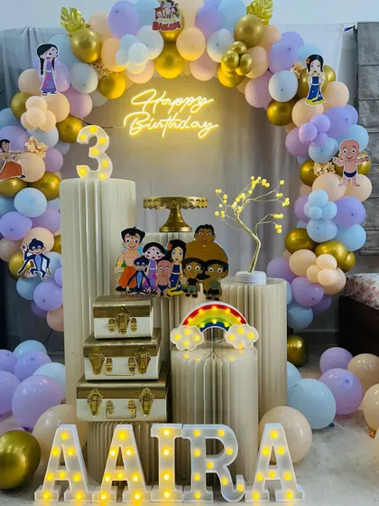 A Chhota Bheem themed third birthday party. This setup uses pastel balloons, character cutouts, and a neon sign for a unique take on the popular theme.