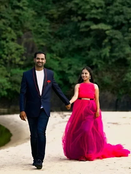 A happy couple walking on the beach. The flowing pink gown is perfect for a relaxed and romantic pre-wedding shoot by the water.