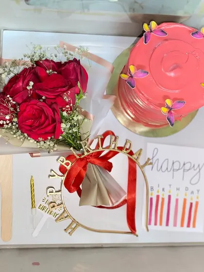 Surprises taste sweeter in a hamper. This custom birthday box includes a pretty pink cake, a bouquet of red roses, a birthday crown, and a card.