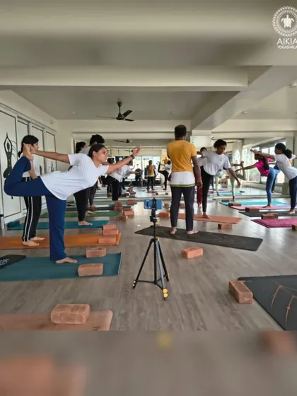 The first day of TTC includes foundational balancing poses. This wide shot shows the entire class working on their stability and focus, setting the tone for the rigorous training ahead.