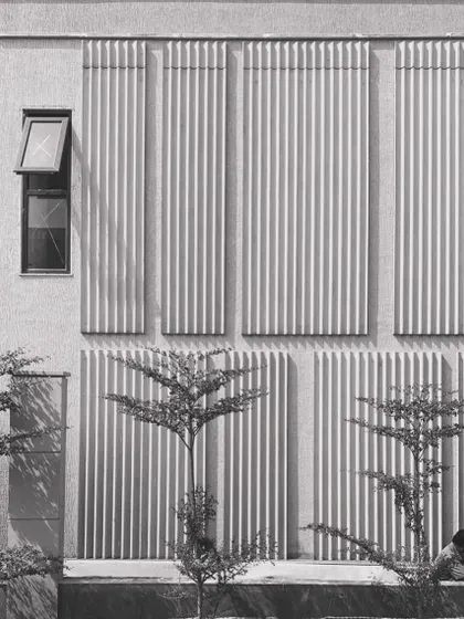 A black and white shot focusing on the composition of concrete fluted panels on the facade of 'Udyāna'. This detail shows the rhythmic and textural quality of the building's skin.