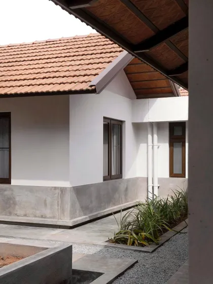 The architecture creates a series of small, landscaped courts and pathways around the building. These spaces manage rainwater and allow for pockets of planting close to the house.