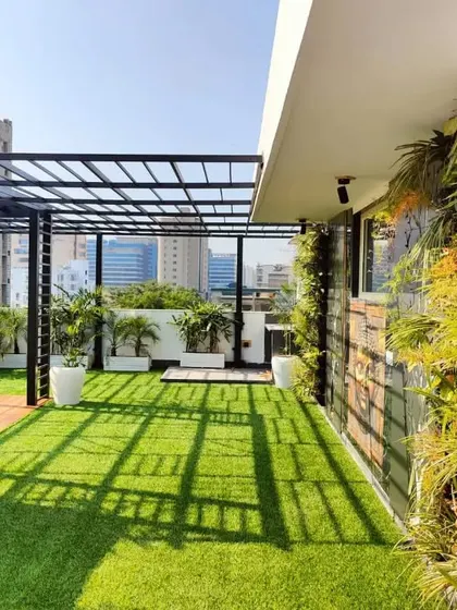 A wide shot of the South City 2 terrace, showcasing the long vertical garden, pergola, and planters that transform the entire length of the space.