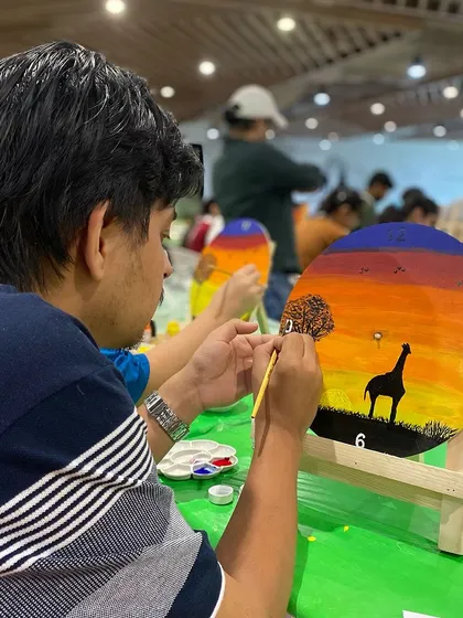 An employee from LinkedIn carefully adding details to their clock painting. The focus and creativity in the room were inspiring.