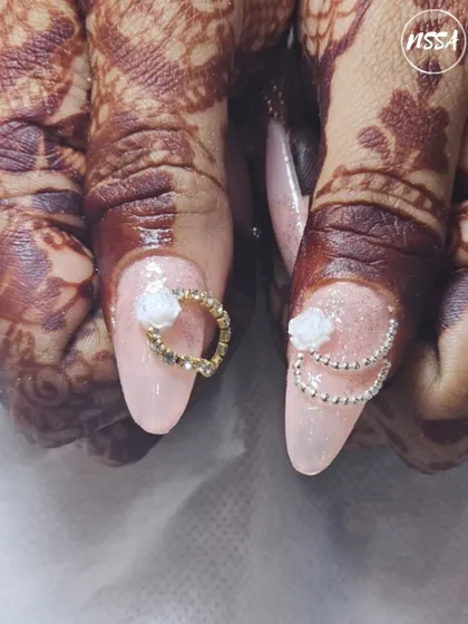 Here's a beautiful example of student work for a bridal theme. They've combined a soft, shimmery base with 3D white roses and intricate beadwork, showing their growing skill in creating elegant designs.