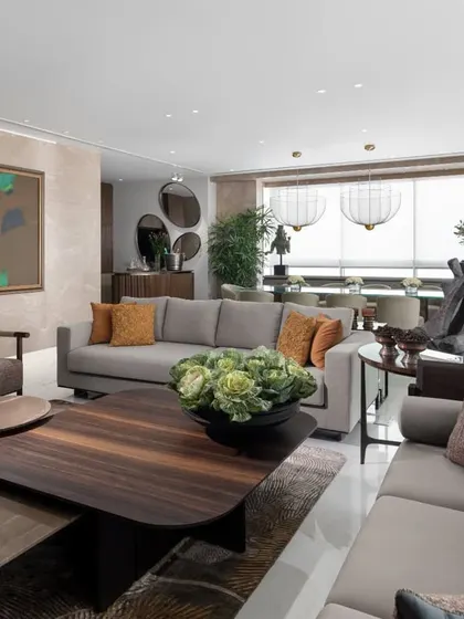 Natural light floods this living room, highlighting the rich materials and thoughtful composition. The space is designed for entertaining, with multiple seating areas that encourage conversation, all centered around our custom Koko coffee tables and grounded by a luxurious rug.
