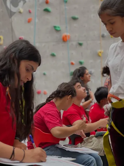 A behind the scenes look at the Warrior of the Wall competition. Here, a young climber gets ready while our staff finalizes scores, ensuring a smooth and fair event for everyone.