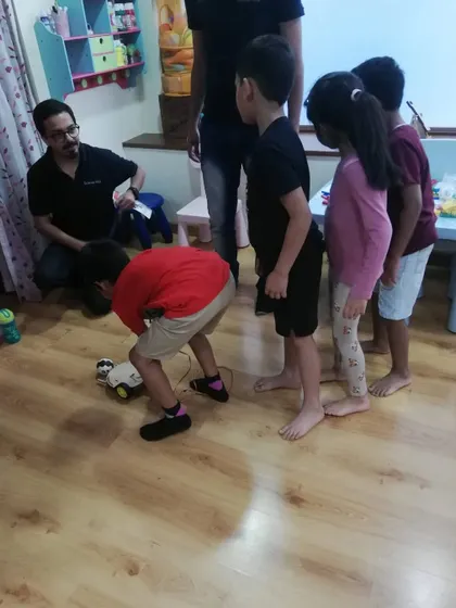 Students gathered around to test a robot they built. Teamwork and peer learning are key components of our teaching philosophy.