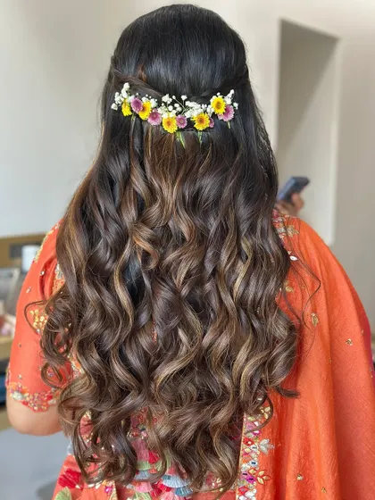For a softer, more bohemian vibe perfect for a Mehendi, I styled these curls and added a simple, colorful floral clip to the back.