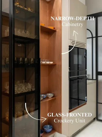 This tall unit features a glass-fronted crockery section and narrow-depth cabinetry, continuing the warm copper story from the rest of the kitchen. It’s a beautiful example of turning a structural element into a design feature.