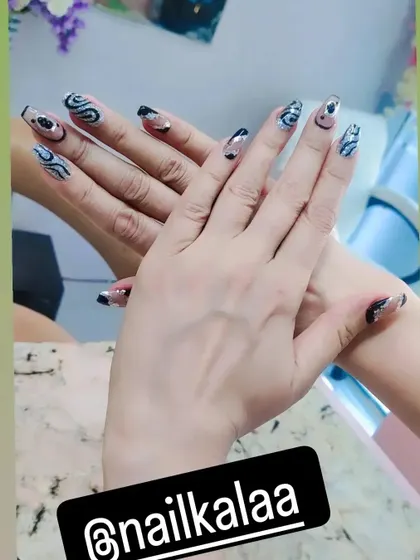 A modern and abstract design with a sheer base and swirls of black and silver glitter.