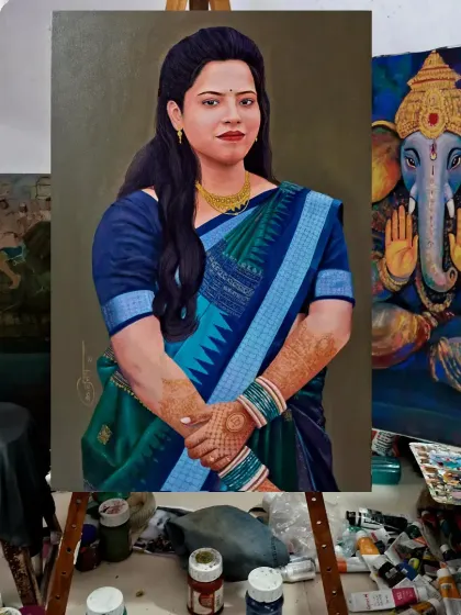A finished portrait of a woman in a saree, seen here in my studio next to another work in progress. This view shows the painting in the context of its creation, surrounded by the tools of my trade.