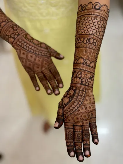 An intricate bridal design with dense patterns covering the hands and forearms.