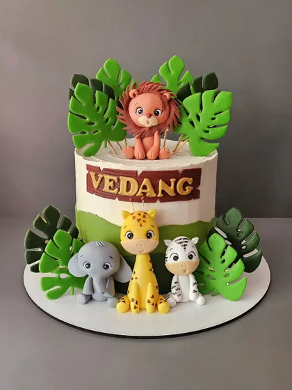 Welcoming baby Vedang with this sweet jungle-themed cake. The vanilla and strawberry cake is decorated with cute, friendly fondant animals like a lion, elephant, giraffe, and zebra.