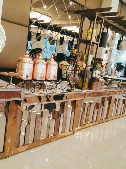 A modern buffet counter with a mirrored, cityscape-style base and copper-toned accents. This setup is perfect for corporate events or contemporary weddings, blending style with function.