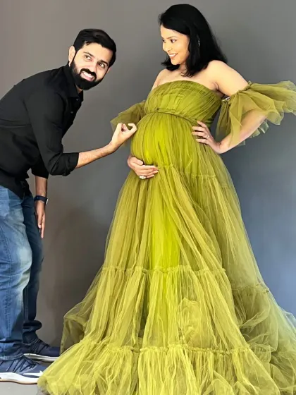 From baby kicks to fashion flicks, this journey is all heart. This playful shot shows the fun and excitement of expecting, with the dad-to-be admiring the bump. The olive green tulle gown and his simple black shirt make a great pair for a studio shoot.
