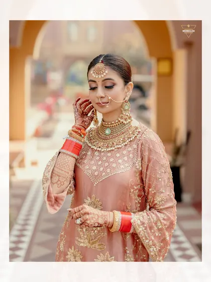 A close-up portrait of the bride, highlighting the intricate details of her makeup, jewelry, and the beautiful embroidery on her outfit.