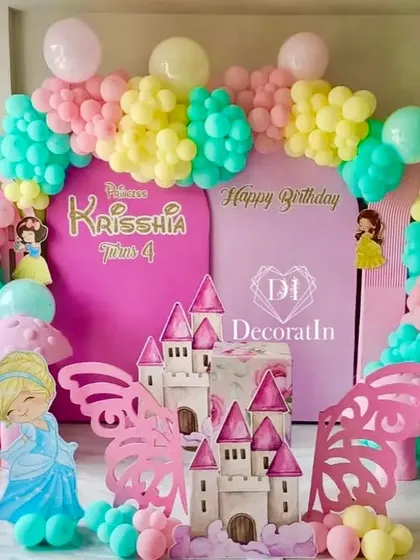 A Disney Princess dream come true. This vibrant setup for a 4th birthday features a castle prop, character cutouts of Belle, Cinderella, and Snow White, and a bright, colorful balloon arrangement.